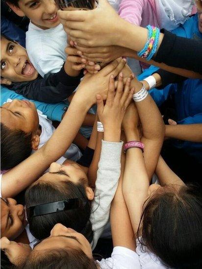 Children with their hand on the baton in Ward End Park