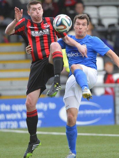 Billy Joe Burns of Crusaders and Glenavon's Kyle Neill compete for the ball during the Irish Premiership match at Seaview