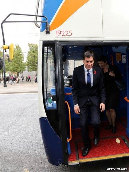 Ed Miliband steps from bus