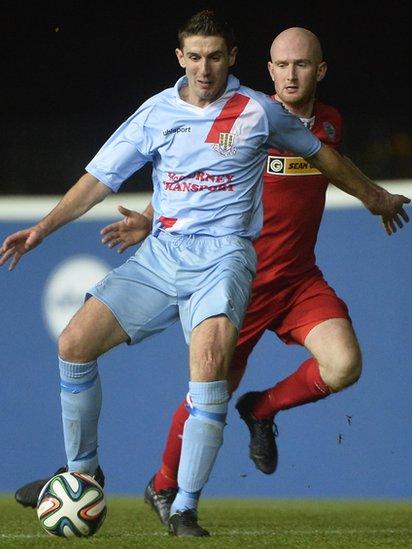 Ballymena United midfielder Gary Thompson on the ball as Cliftonville opponent Ryan Catney closes in