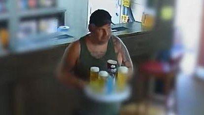 Steven Naylor in a bar blurred out carrying a tray of alcoholic drinks 