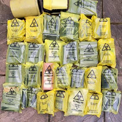 Yellow sharps bags with the word biohazard line the floor. Inside each one is a sharps box.