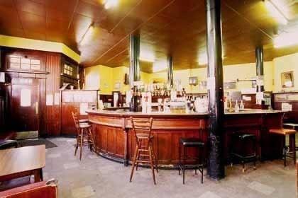 A traditional Scottish bar with a curved serving area and stools