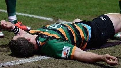 George North of Northampton Saints lays injured after colliding with Nathan Hughes of Wasps in