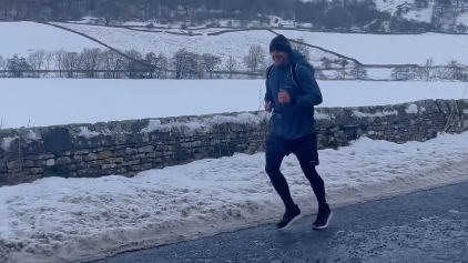 Jay Taylor running along a road in the snow