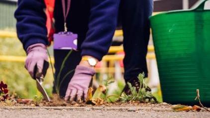 A person gardening at a train station 