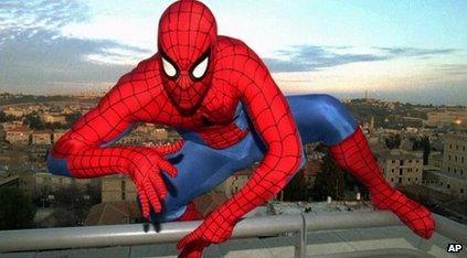 Spiderman crouching on a building