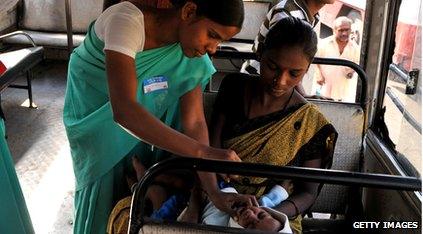 lady giving medicine to mother and baby on a bus