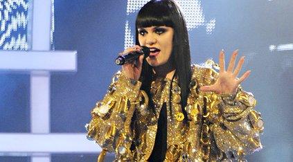 Jessie J performing in a golden, fluffy poncho