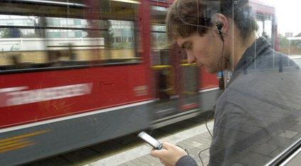 man on mobile phone as bus passes by