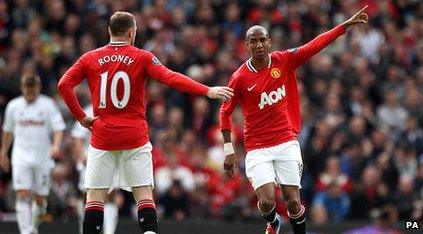 Ashley Young waving to Wayne Rooney