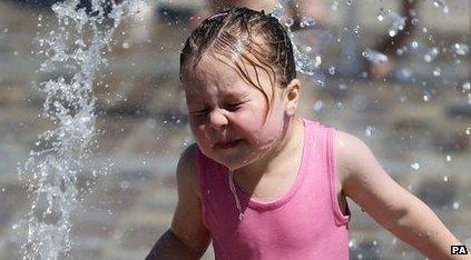 Girl plays in a water fountain