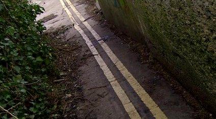 A double-yellow line in a tiny alleyway