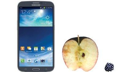 The Galaxy Mega next to an apple and a blackberry