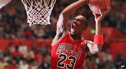 Michael Jordan slams a basketball into a net