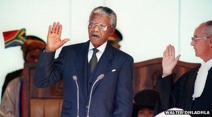 Nelson Mandela raises his right hand as he is speaking