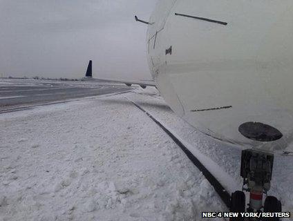 A plane which has skidded off the runway surrounded by snow