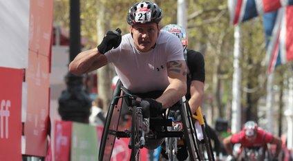 David Weir raises his fist as he wins the London Marathon
