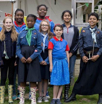 Girls in the new Girlguide uniform alongside girls in vintage uniforms