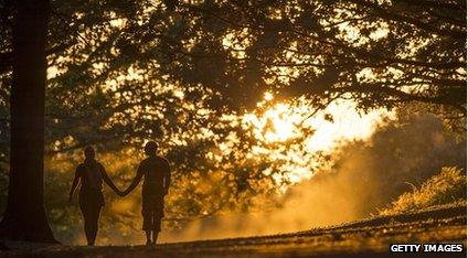 A couple walk through Richmond Park at sunset on September 12