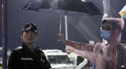 A young pro-democracy demonstrator holds an umbrella for a police officer during a demonstration in Hong Kong on 30 September 2014.