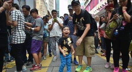 A father stands next to his son as he shouts pro-democracy slogans at a protest site in Hong Kong on 1 October 2014.