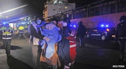 Medics help migrants after they arrived onboard the Blue Sky M cargo ship at the Gallipoli harbour southern Italy, on 31 December 2014.