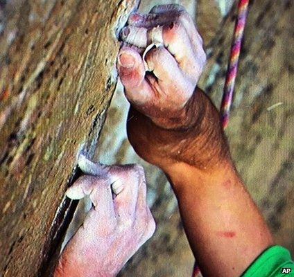 A climber holds on to rocks