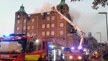 Smoke is seen coming from the top level of the University Arms Hotel in 2013. Two fire engines can be seen.