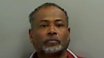 Mugshot of Nallathamby. He has short black hair and a white goatee beard.