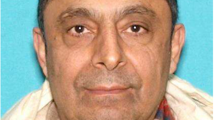 The suspect, standing for his drivers license photo