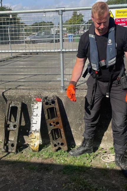 PC Whittington standing with two metal bars that were recovered from Beverley Beck