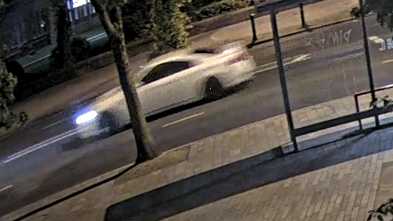 A blurred image of a white car driving down a road