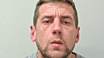 Martin Glover, 39, in a police mugshot photograph. He has short fair-to-dark hair and stubble. 