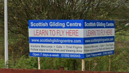 A sign for the Scottish Gliding Centre with white lettering on a blue background