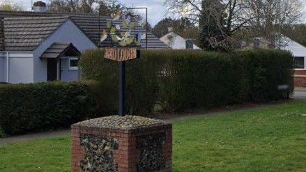 A general view of the Red Lodge village sign. The sign sits on a square of red bricks.