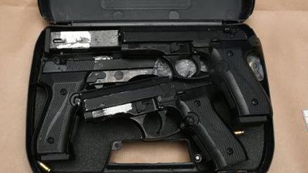 A black case, with three guns inside and a number of bullets