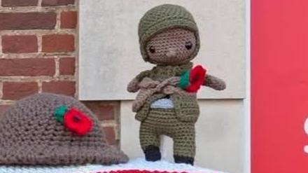 This image shows the knitted soldier before he went missing. He is wearing a knitted green uniform with a red poppy attached to his chest and black boots.