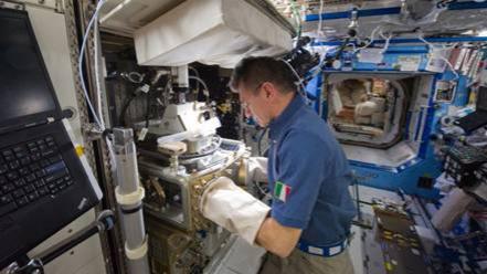 Italian astronaut Paolo Nespoli conducting experiments on the space station