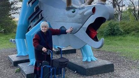 Genevieve Glatt, using a walker, with her largest triceratops