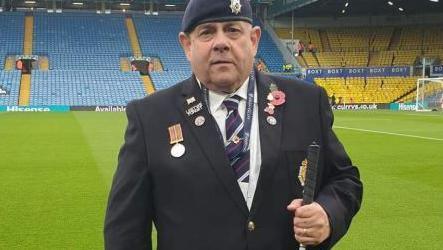 Chris Fella on the pitch at Elland Road. Mr Fella is wearing his blue military beret and medals, a blue jacket and regimental tie