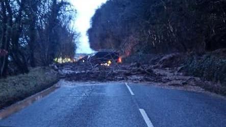 A picture of a tree and mud debris blocking the A832 Fortrose to Avoch road on the Black Isle. The image was captured on a mobile phone from the front seat of a vehicle.