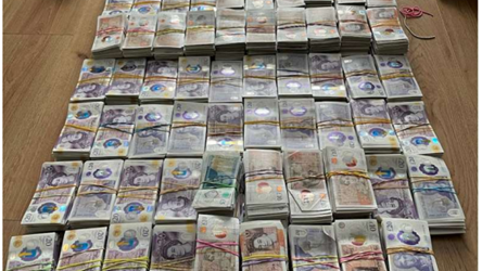 Wads of bank notes tied up in elastic bands on the floor of a property.