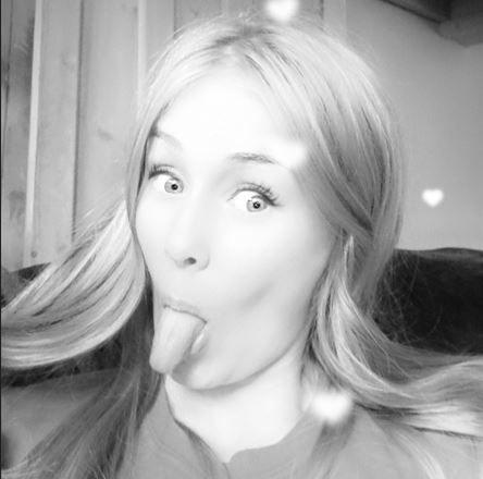 Rhianan sticking her tongue out for the camera. The image is in black and white. 