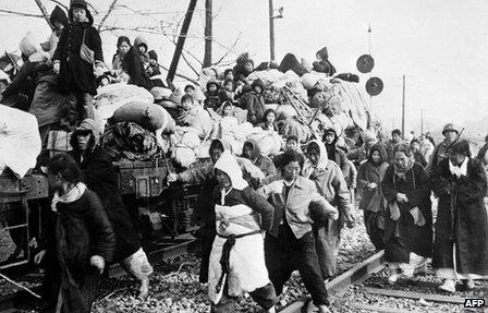 Korean refugees head south on board flatbed trains from Pyongyang in 1951.