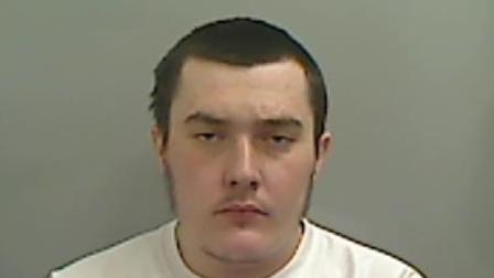 Mugshot of a man in a white t-shirt with short brown hair.