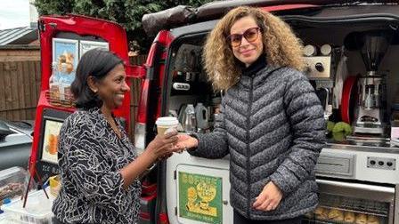 Inthu Rajah receiving a cup of coffee