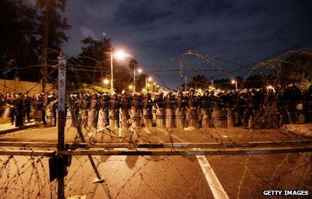 Egyptian riot police stand behind barbwire