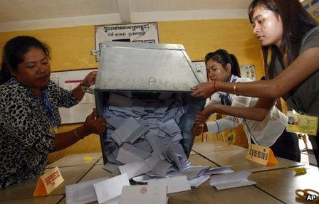 Officials open a ballot box for counting