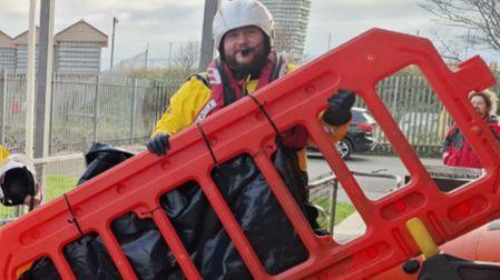A crew member holds a large red plastic fence